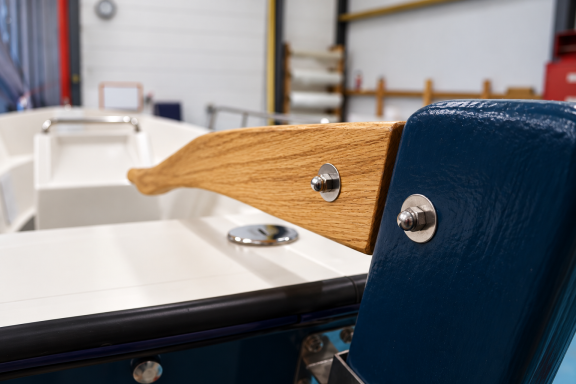 Handcrafted tiller detail Close-up of the Aquasea wooden tiller and blue rudder fittings.